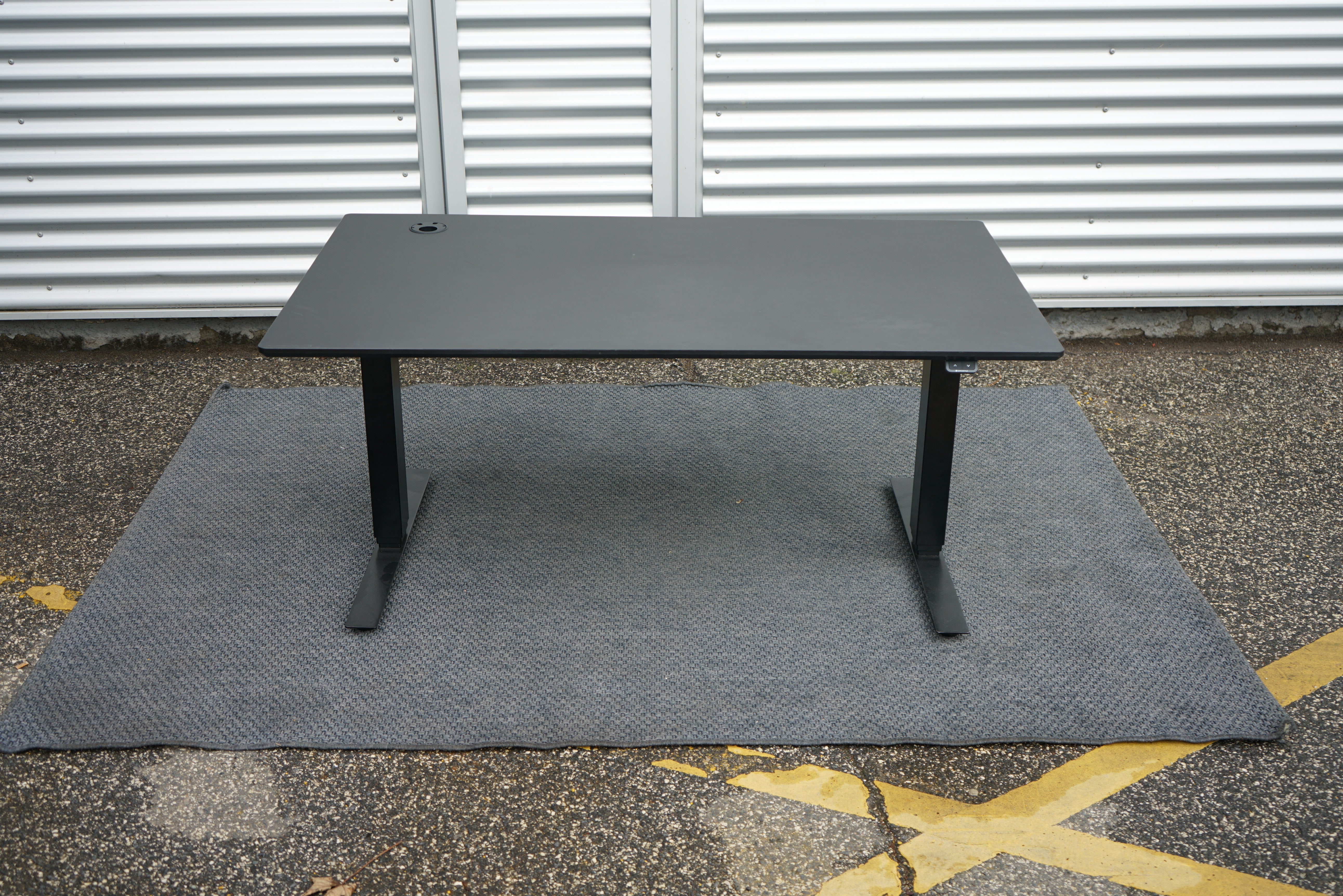 Martela hæve-sænkebord i sort med integreret stikkontakt – set forfra.